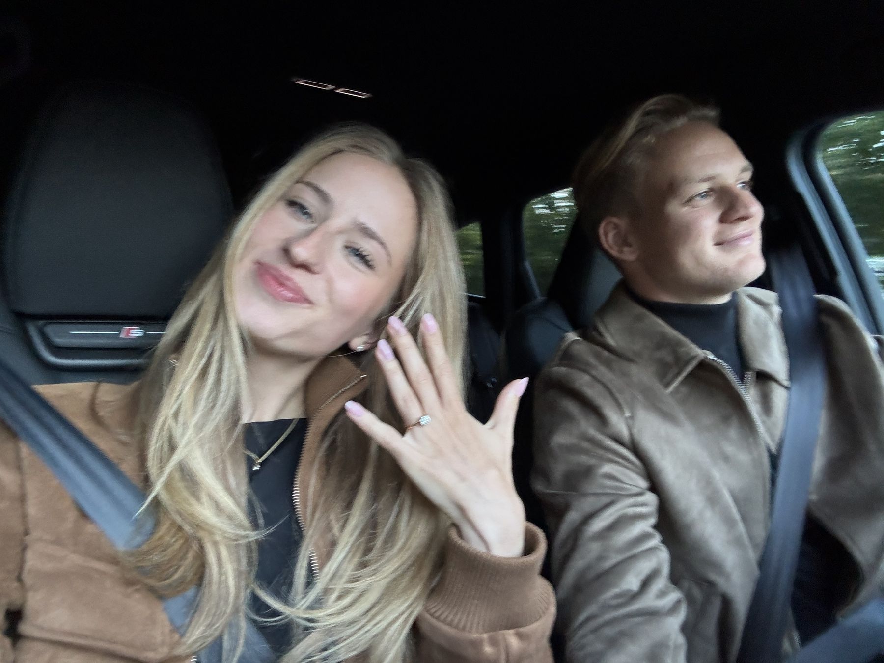 Sophia zeigt im Auto ihren Verlobungsring, Luis sitzt am Steuer