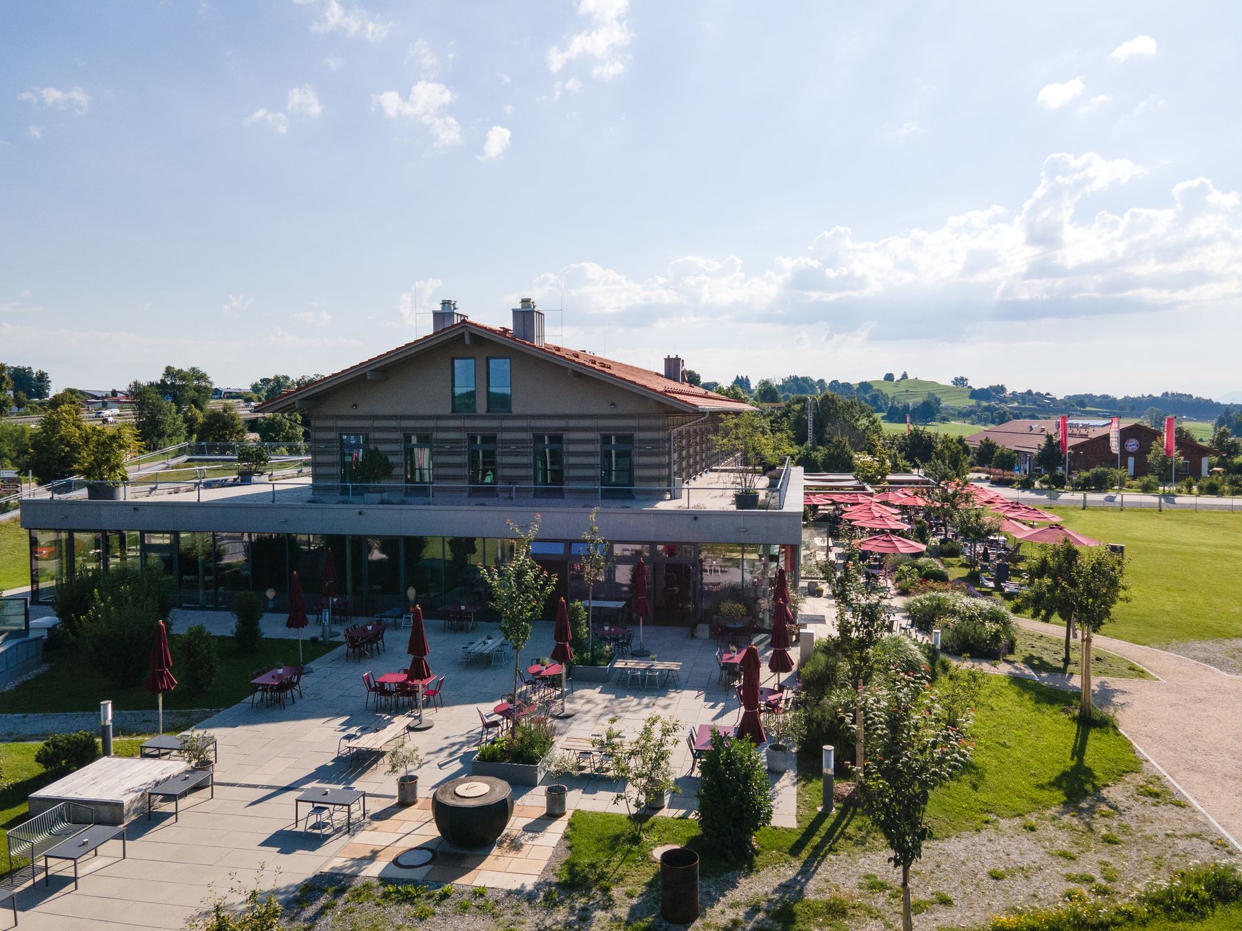 Das Hauptgebäude der DINZLER Kaffeerösterei am Irschenberg mit Blick auf die Berge